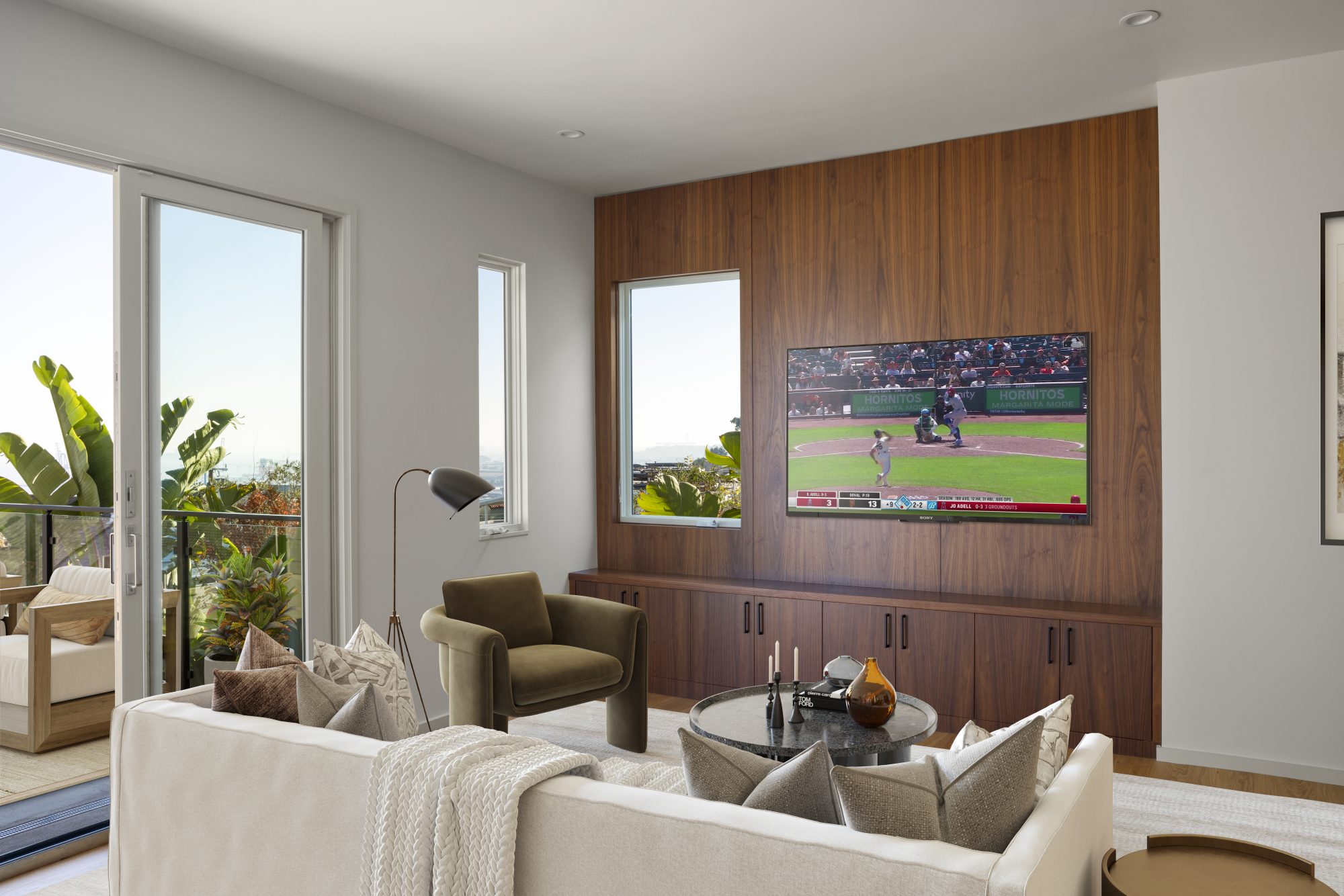 Living room with walnut TV accent wall, olive velvet chair, and ocean views
